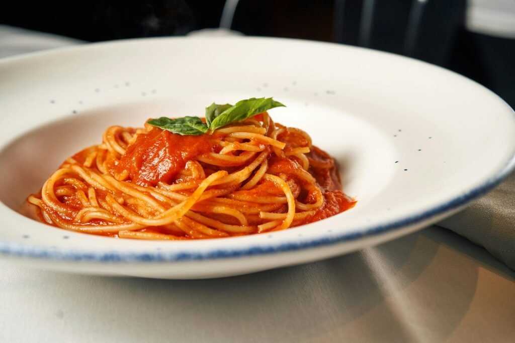 A delightful plate of spaghetti topped with savory tomato sauce and fresh basil.