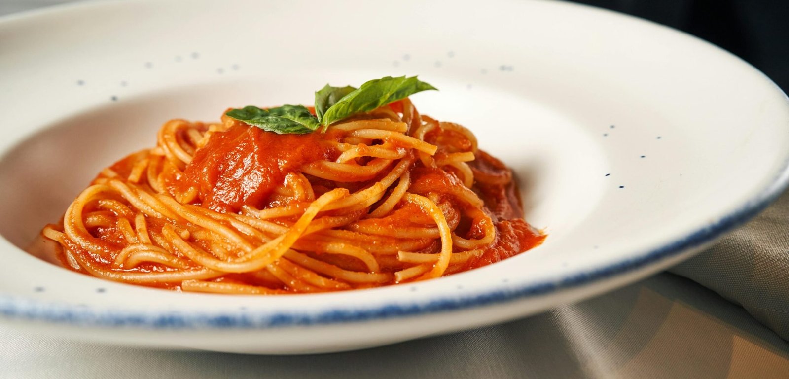 A delightful plate of spaghetti topped with savory tomato sauce and fresh basil.